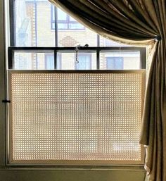 an open window with a curtain in front of it