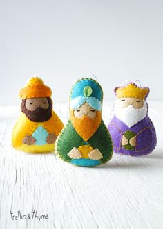 three felt nativity dolls sitting next to each other