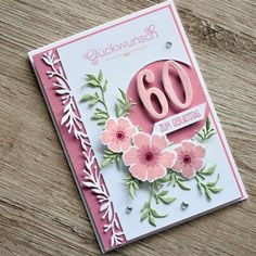 a close up of a greeting card with flowers on it and the number 60 written in pink