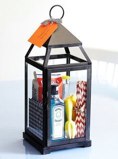 a small black lantern with an orange tag hanging from it's side on a table