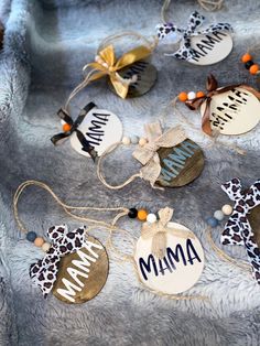 some ornaments that are on top of a silver cloth covered table with the word mama