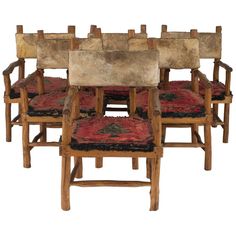 four wooden chairs sitting next to each other on top of a red rug in front of a white background