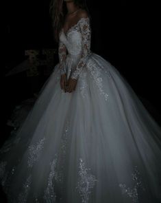 a woman in a white wedding dress is posing for the camera with her hands on her hips