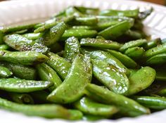 a white bowl filled with green beans on top of a table