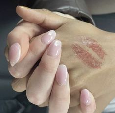 a woman's hand holding onto the arm of another person with pink nail polish on it