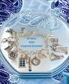 a bracelet with charms on it sitting on top of a glass plate next to a book