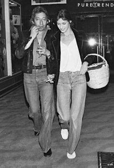 black and white photograph of two people walking down the street