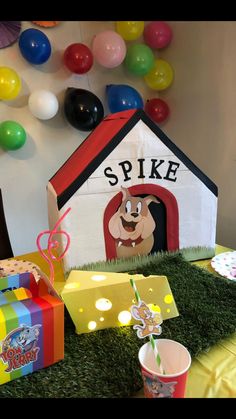 there is a dog house and some boxes on the grass with balloons in the background