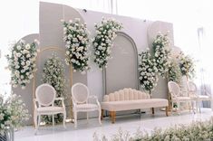 a room filled with lots of white furniture and flowers