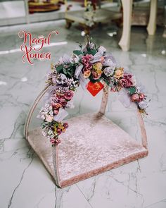 a flower arrangement on top of a chair in the middle of a room with marble flooring