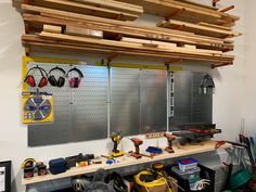 a workbench with many tools and accessories hanging from it's ceiling,