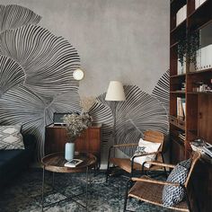 a living room with two chairs and a table in front of a book shelf filled with books