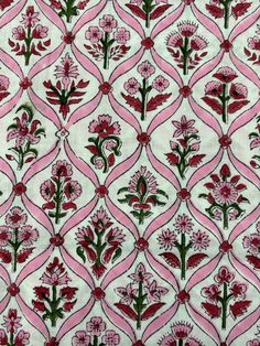 a pink and green floral print on white fabric with red flowers in the center, surrounded by wavy lines