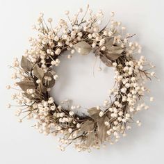 a wreath with white flowers and green leaves on a white background, ready to be used as an ornament