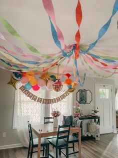 colorful streamers hang from the ceiling above a dining room table