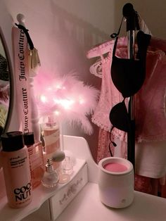 a vanity with pink lights and cosmetics on it