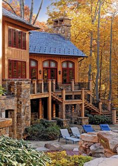 a wooden house surrounded by trees in the fall