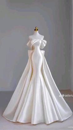 a white wedding dress on display in a room