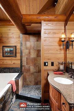 a bathroom with wood paneling and stone counter tops, along with a large bathtub