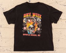 Y2K vintage Myrtle Beach Bike Week t-shirt. Based on our hand measurements, the recommended modern unisex size for this garment is LARGE. HOWEVER, you should review the garment's actual measurements provided in the photos prior to purchasing. To ensure correct fit, we recommend comparing those measurements with the measurements of a similar garment in your closet. Graphic Print Tops For Biker Events In Summer, Graphic Print Tops For Summer Biker Events, Biker Style T-shirt For Summer Streetwear, Biker Style Streetwear T-shirt For Summer, Black Biker T-shirt For Summer, Summer Biker Style Cotton T-shirt, Biker Style Cotton T-shirt, Summer Biker Cotton T-shirt, Cotton Biker T-shirt