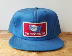 Rare New old Stock original vintage (late 1970's to early 1980's era) MR. AUTOMOTIVE hat!  Fully sewn 6 panel construction incl patch, full foam insulation,  6 ventilation holes and an adjustable snapback closure.  Made in USA by "Par-Line" Condition: Excellent deadstock shape!  Mint or near mint "Medium" Adjust-A-Tab. Fits hat sizes 6 7/8 thru 7 1/2 (max) Vintage Blue Adjustable Trucker Hat, Vintage Blue Snapback Baseball Cap, Vintage Blue Hat With Flat Brim, Vintage Blue Flat Brim Hat, Vintage Blue Adjustable Baseball Cap, Vintage Adjustable Blue Baseball Cap, Retro Blue 5-panel Trucker Hat, Retro Baseball Cap With Curved Brim, Blue Vintage Baseball Cap With Curved Brim