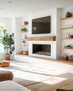 a living room filled with furniture and a flat screen tv mounted on the wall above a fire place