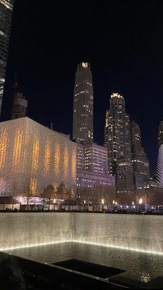 the city skyline is lit up at night with skyscrapers in the backgroud