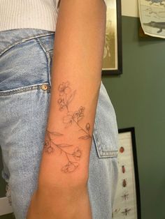 a woman's arm with a flower tattoo on the left side of her arm