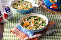 two bowls of chicken noodle soup on a green and white checkered tablecloth