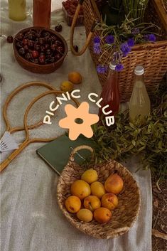 a table topped with baskets filled with fruit next to bottles of juice and other items