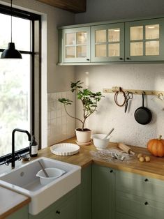 a kitchen with green cabinets and wooden counter tops