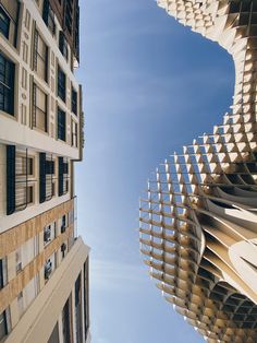 looking up at two tall buildings from the ground, with one building in the foreground