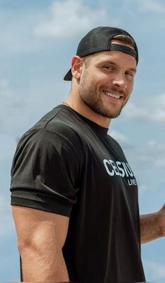 a man holding a frisbee in his right hand and smiling at the camera