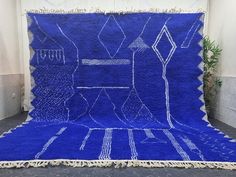 a large blue rug with white lines on it and fringes hanging from the sides