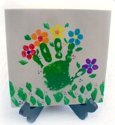 a hand print on a card holder with flowers and leaves painted on it's sides