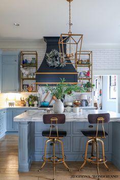 a kitchen with blue cabinets and gold accents