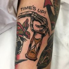 a person with a tattoo on their arm holding an hourglass