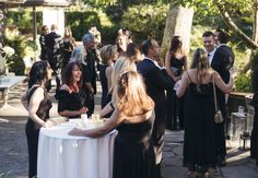 a group of people standing around a white table