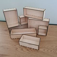 several empty boxes sitting on top of a wooden table next to each other with one open