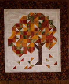 a quilted wall hanging with a tree on it