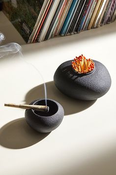 A versatile match striker, match holder and ashtray by Houseplant featuring a stacked pebble silhouette. Made from super heavy-duty cast iron, this multi-tasking essential features a strike-anywhere texture allover to ignite your matches, a cutout in the central vessel to hold your matches, and an ashtray built into the top pebble to hold your rolled herbs. Features Multi-tasking ashtray & match strike by Houseplant Stacked pebble silhouette Cast iron construction Ashtray built into the top tier Cutout in bottom tier to hold matches - matches sold separately Leather base Recommended for use with strike-anywhere matches Content + Care Matches sold separately Cast iron, leather Wipe clean Imported Size Lid dimensions: 1.63" h Base dimensions: 2.1" h Weight: 5.5 lbs | Houseplant Pebble Match Texture Allover, Crochet Blanket Vintage, Matchstick Holder, Faux Christmas Trees, Pinch Bowls, Ceramic Ashtray, Match Striker, Match Holder, Metal Curtain