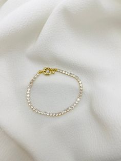 Description: Delicate cubic zirconia bracelet with sailor clasp Material: 18k gold plated, 3 A cubic zirconia Measurement: 3mm width, 7" length Tarnish resistant, water resistant, hypoallergenic Cubic Zirconia Bracelet, Body Lotion, Cubic Zirconia, 18k Gold, Gold Plate, Water Resistant, Plating, Bracelet, Water