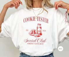 This cookie tester social club shirt is the perfect addition to your holiday festivities! It's a fun and unique way to commemorate your Christmas baking tradition.  **DETAILS** This Comfort Colors 1717 unisex t-shirt is soft and lightweight, the comfiest shirt you will own! It's comfortable and flattering for both men and women.  - Unisex sizing please refer to sizing chart in listing photos - 100% combed and ring-spun cotton  - Medium fabric weight - Relaxed fit **PRINTING** - DTG (Direct To Ga Shipping Products, Group Shirts, Comfy Shirts, Club Shirts, Christmas Cookie, Social Club, Holiday Baking, Family Holiday, Christmas Baking