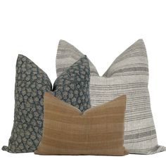 three pillows with different patterns on them, one is brown and the other is blue