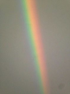 a rainbow shines brightly in the sky