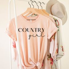 Country Girl T-shirt Black or White Print-country girl shirt- Country Shirt - Gift For Friend - Shirt Country girl - Country gift-country music shirt-Country T This classic unisex jersey short sleeve tee fits like a well-loved favorite. Soft cotton and quality print make users fall in love with it over and over again. These t-shirts have-ribbed knit collars to bolster shaping. The shoulders have taping for better fit over time. Dual side seams hold the garment's shape for longer.  .: 100% Airlume combed and ringspun cotton (fiber content may vary for different colors) .: Light fabric (4.2 oz/yd² (142 g/m .: Retail fit .: Tear away label .: Runs true to size Graphic Tee For Spring Country Concerts, Graphic Tee For Country Events With Short Sleeves, Short Sleeve Graphic Tee For Country Events, Cotton Crew Neck T-shirt For Country Events, Graphic Tee With Letter Print For Country Festivals, Country Style Pre-shrunk Cotton T-shirt, Country Style T-shirt For Spring Events, Summer Crew Neck Tops For Country Events, Spring Country Style T-shirt For Country Events