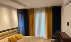 a bedroom with a large bed and yellow pillows on the headboard, next to a wall mounted air conditioner