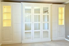 an empty room with white painted walls and built in shelves on either side of the wall