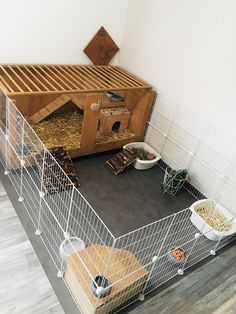 a caged in area with food and other items on the floor next to it