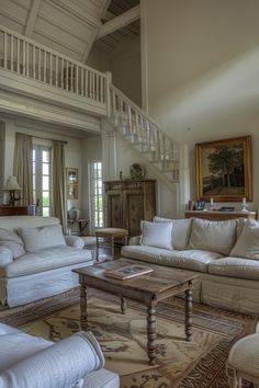 a living room filled with furniture and a stair case in front of the couches